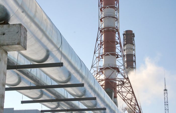 Chimneys of the boiler house and pipes of the heating main with hot water of the central heating